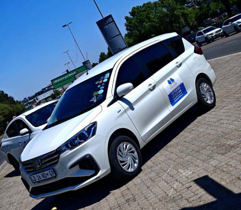 White branded Toyota MPV school transport vehicle