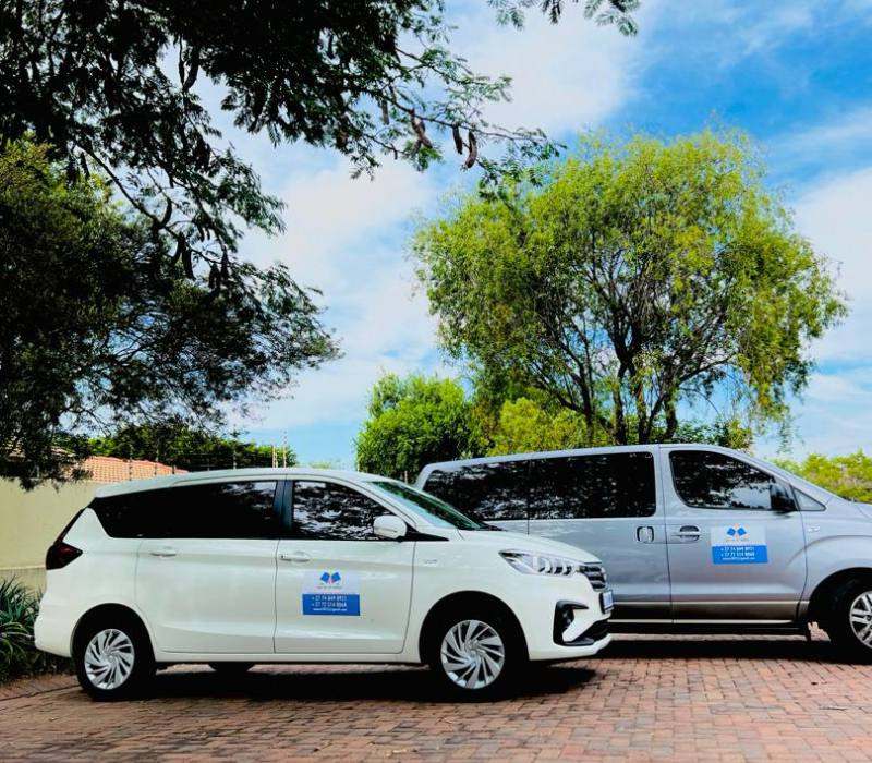 White MPV and silver shuttle van of the Mini Me on Wheels fleet